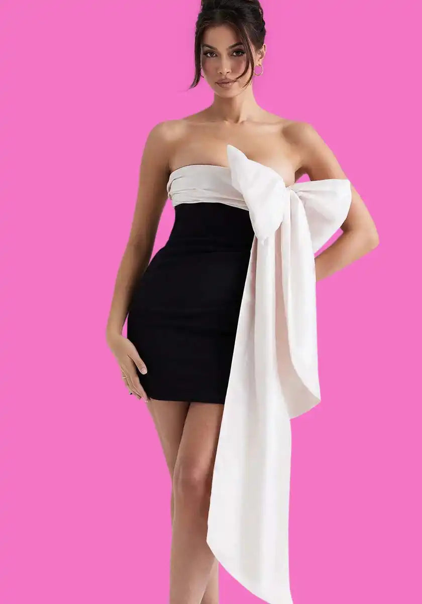 A black and white strapless mini dress with a large white bow accent.